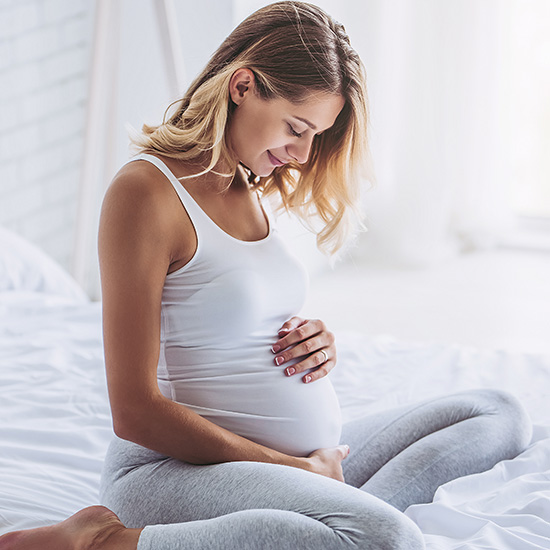 Schwangere Frau hält Bauch