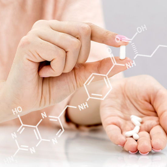 Close-up hands holding capsules and chemical structures