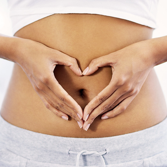 Inulin Pulver wirkt präbiotisch Hände vor Bauch, die ein Herz formen