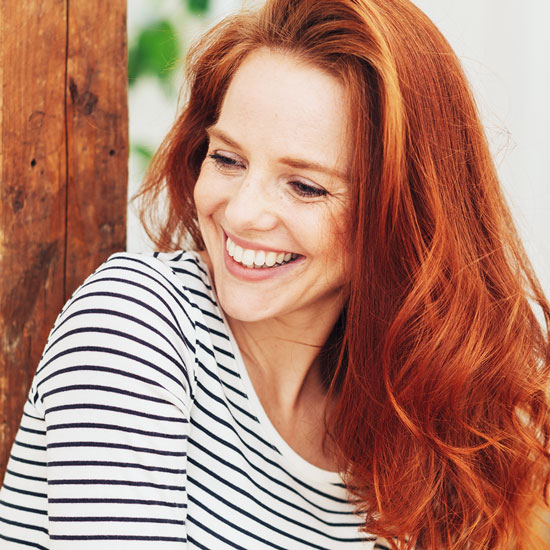 5-HTP - die Vorstufe von Serotonin Glückliche Frau mit roten Haaren