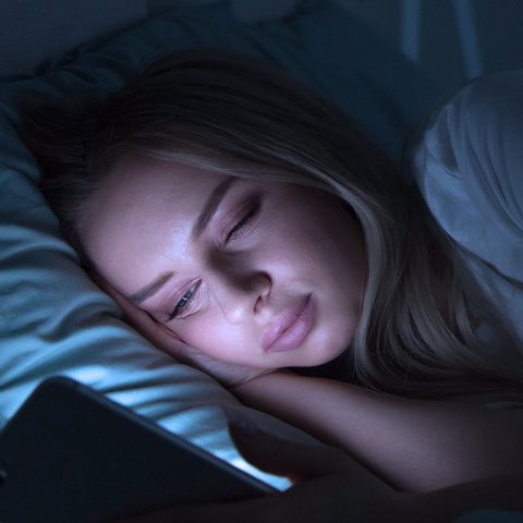 Frau im Bett mit Bildschirm