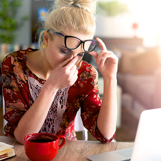 Woman working in front of the computer, feeling tired