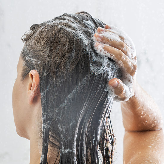 Frau wäscht sich Haare mit basischem Shampoo