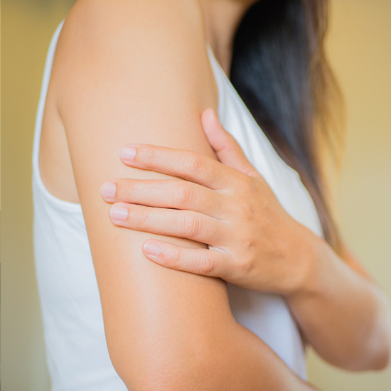 Close-up woman holding her arm with the hand