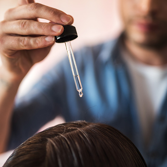 Pipette verteilt Fluid auf Haarboden