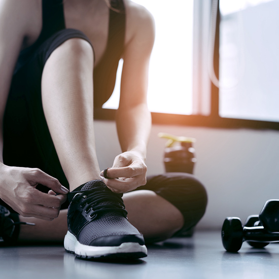 Frau schnürt sich Schuhe bei Training