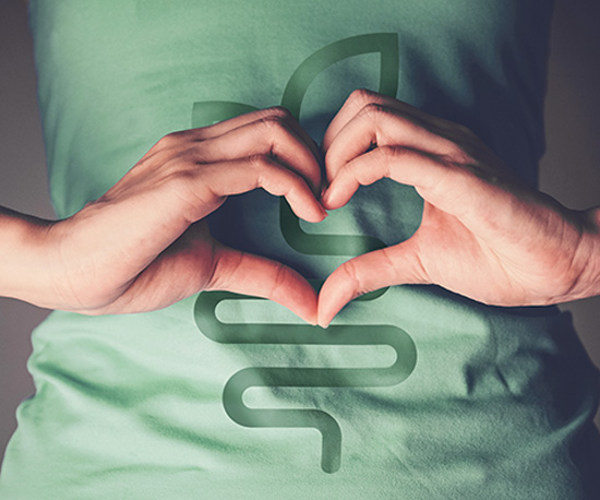 Woman shapes heart with hands in front of intestine