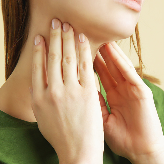 Close-up woman holding her thyroid glands