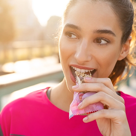 Frau beisst in eiweissreichen Snack