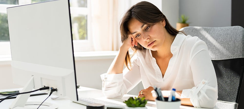Frau sitzt müde vor Computer