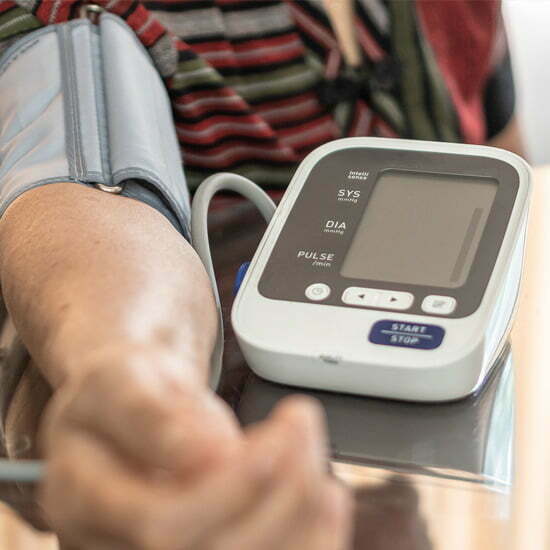 Ein Mann misst mit einem elektonischen Gerät seinen Blutdruck