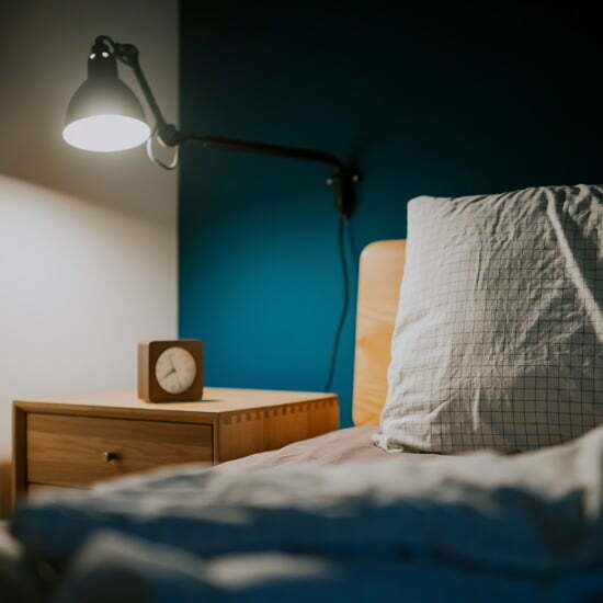 Nachttischlampe, Wecker und Bett