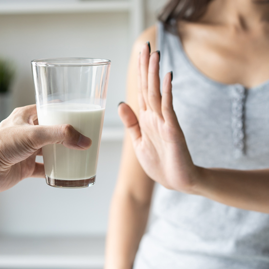 Person lehnt Glas Milch ab.